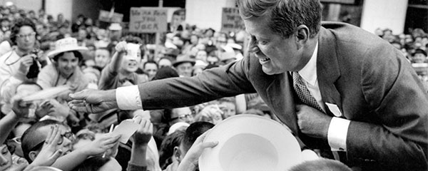 John F. Kennedy offering a handshake. 