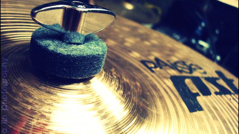 A gold cymbal with a green felt washer on the bell. 