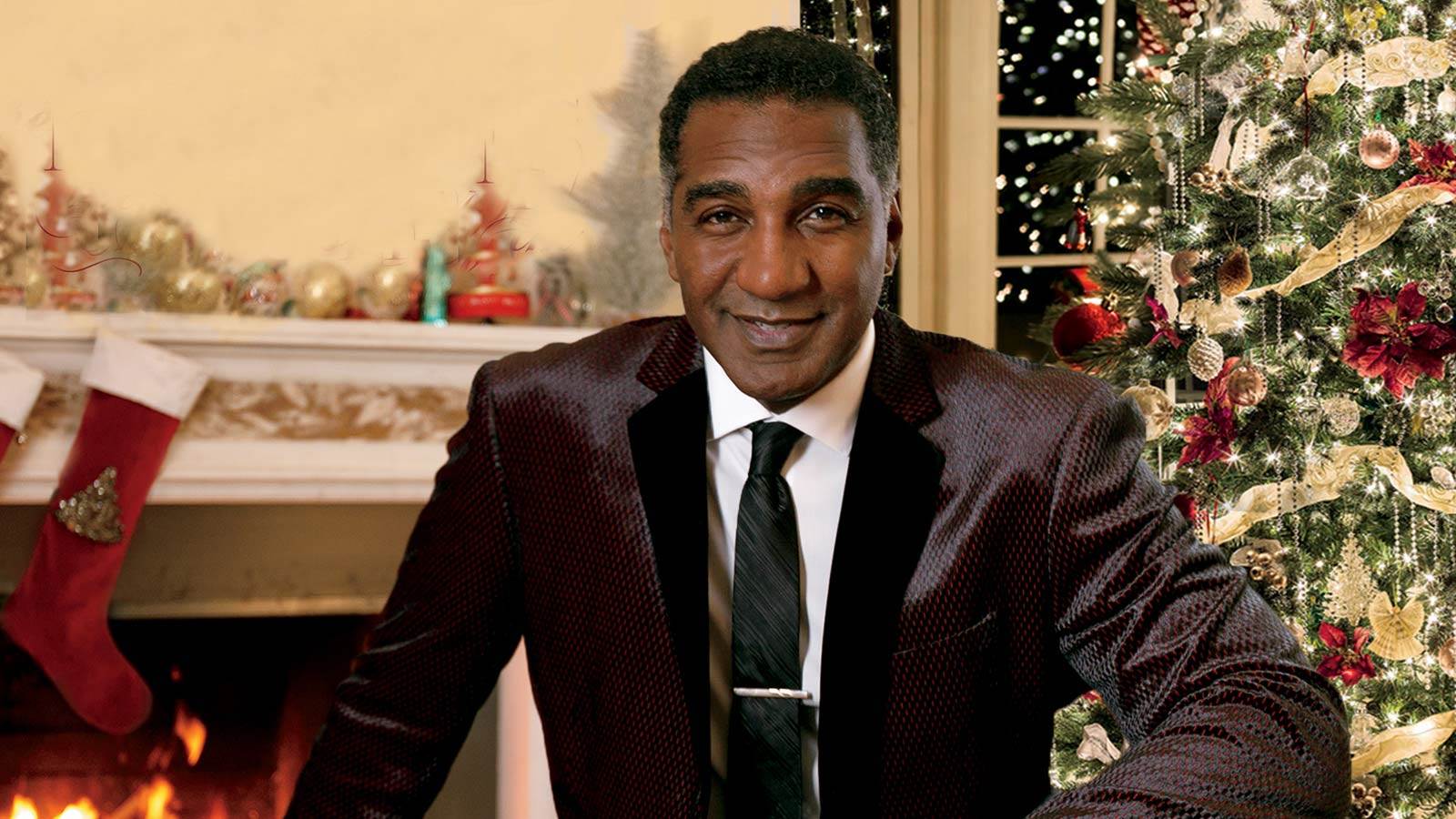 Norm Lewis in Christmas room with fireplace