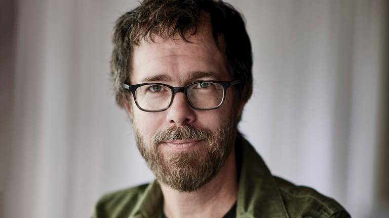 Ben Folds wearing glasses and a green jacket.