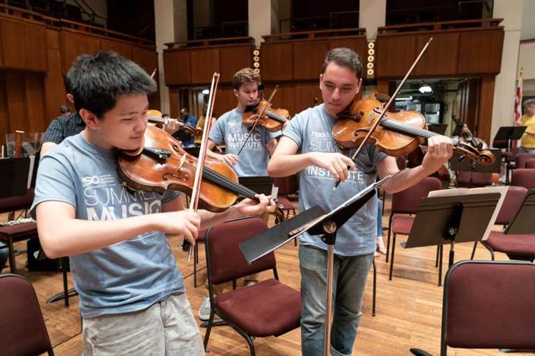 Students participating in a side by side rehearsal with NSO musicians in the Concert Hall. 