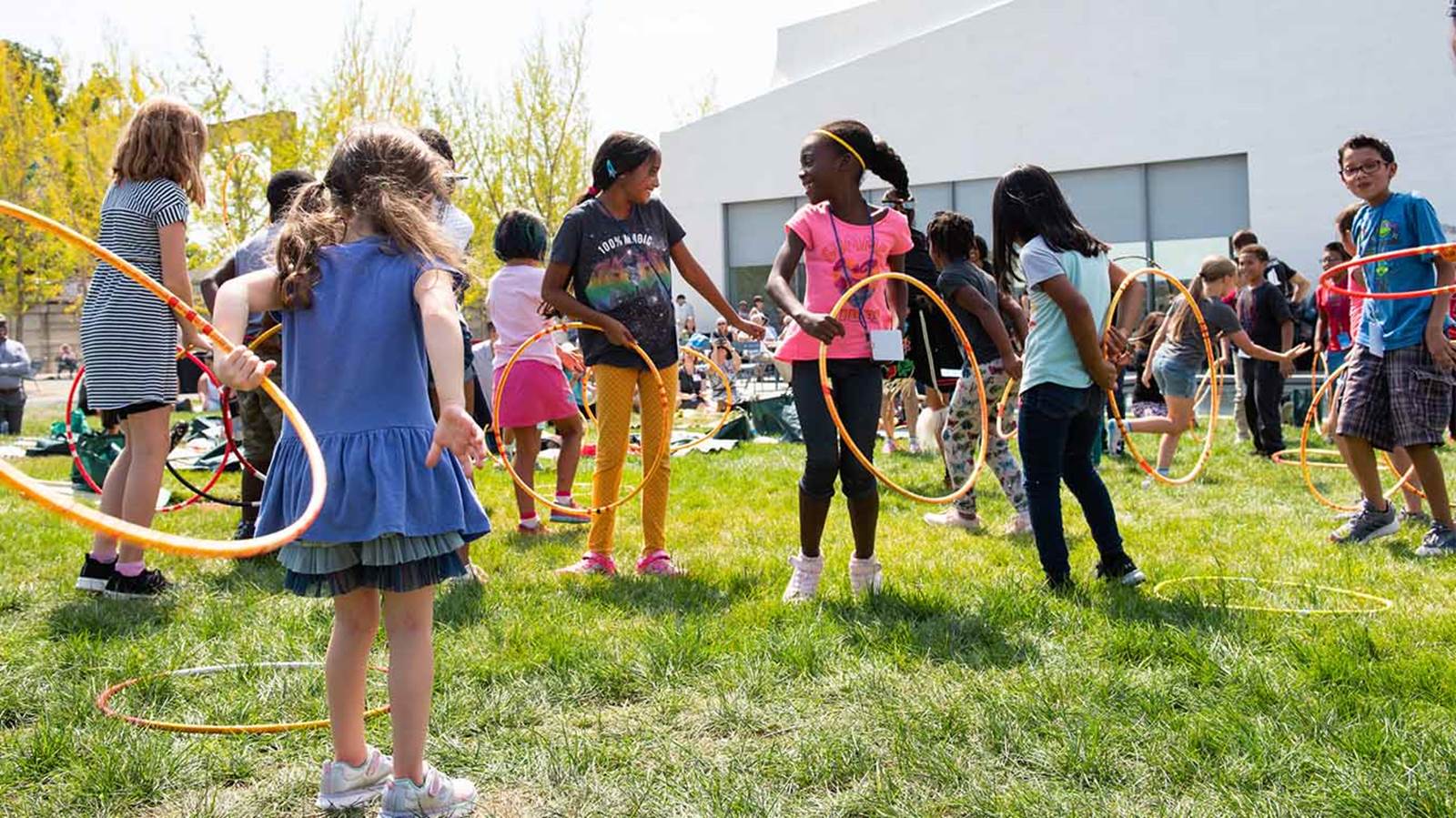 Photo of children playing outside at the REACH with hoops.